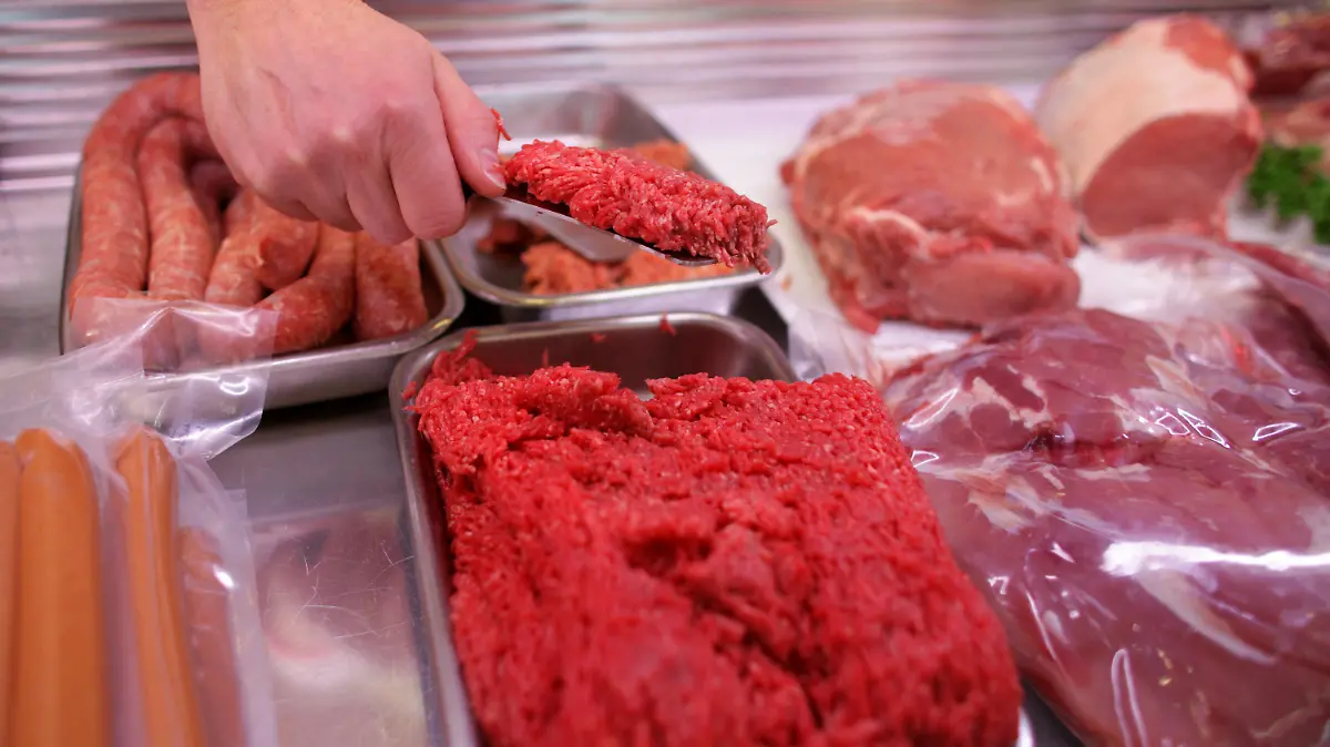 ARCHIV - ILLUSTRATION - Eine Hand entnimmt Fleisch aus einer Fleischtheke, aufgenommen am 10.01.2011 in Köln (Nordrhein-Westfalen). Biofleisch, das keines gewesen sein soll und 100 Kilogramm verdorbene Wurst: Ein Fleischer muss sich in Krefeld vor Gericht verantworten. (Zu dpa/lnw «Fleisch als Bio deklariert, Wurst verdorben: Metzger vor Gericht» vom 25.04.2017) Foto: Rolf Vennenbernd/dpa +++(c) dpa - Bildfunk+++