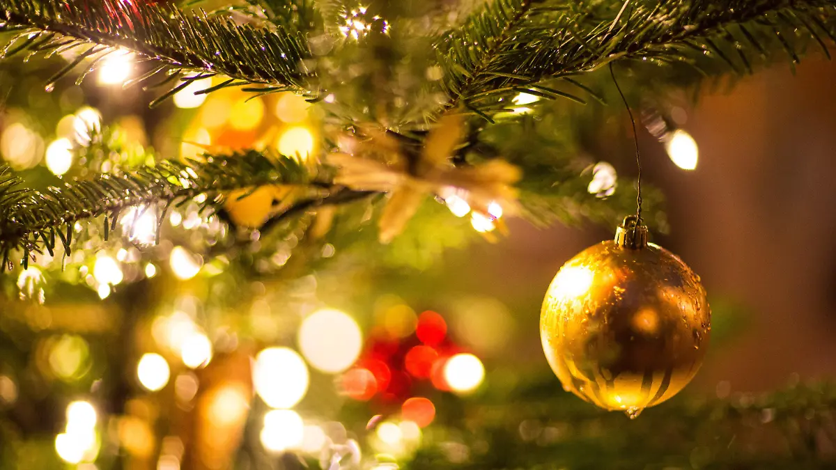 ARCHIV - 09.12.2017, Nordrhein-Westfalen, Bielefeld: Eine goldene Kugel hängt an einem Weihnachtsbaum auf dem Weihnachtsmarkt. (zu dpa: «Umfrage: Mehrheit für weniger Weihnachtsbeleuchtung wegen Klimaschutz ») Foto: Friso Gentsch/dpa +++ dpa-Bildfunk +++
