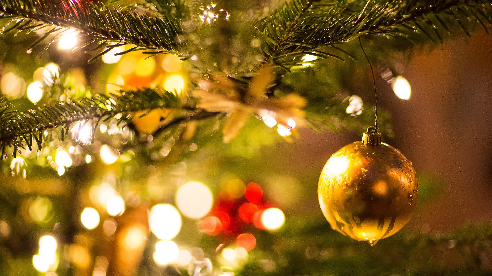 ARCHIV - 09.12.2017, Nordrhein-Westfalen, Bielefeld: Eine goldene Kugel hängt an einem Weihnachtsbaum auf dem Weihnachtsmarkt. (zu dpa: «Umfrage: Mehrheit für weniger Weihnachtsbeleuchtung wegen Klimaschutz ») Foto: Friso Gentsch/dpa +++ dpa-Bildfunk +++