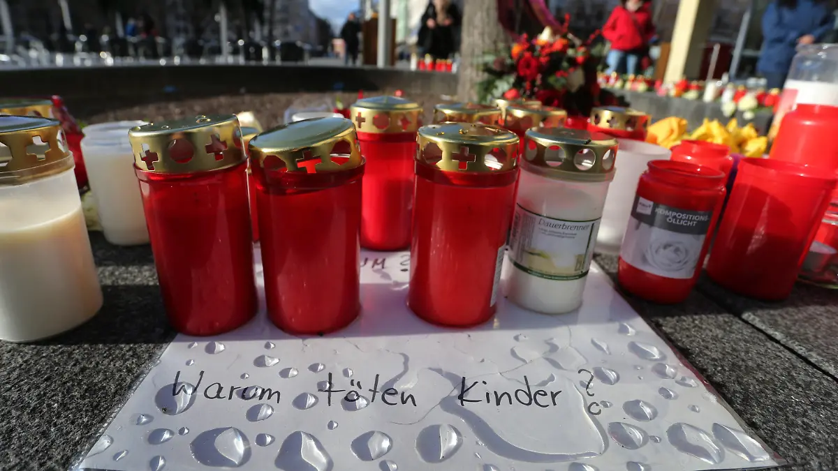 09.12.2019, Bayern, Augsburg: "Warum töten Kinder?" steht am Königsplatz auf einem Zettel zwischen Grablichtern zu lesen. Ein Feuerwehrmann war am Freitagabend (06.12.2019) hier in seiner Freizeit nach einem Schlag so schwer verletzt worden, dass er noch vor Ort starb. Foto: Karl-Josef Hildenbrand/dpa +++ dpa-Bildfunk +++
