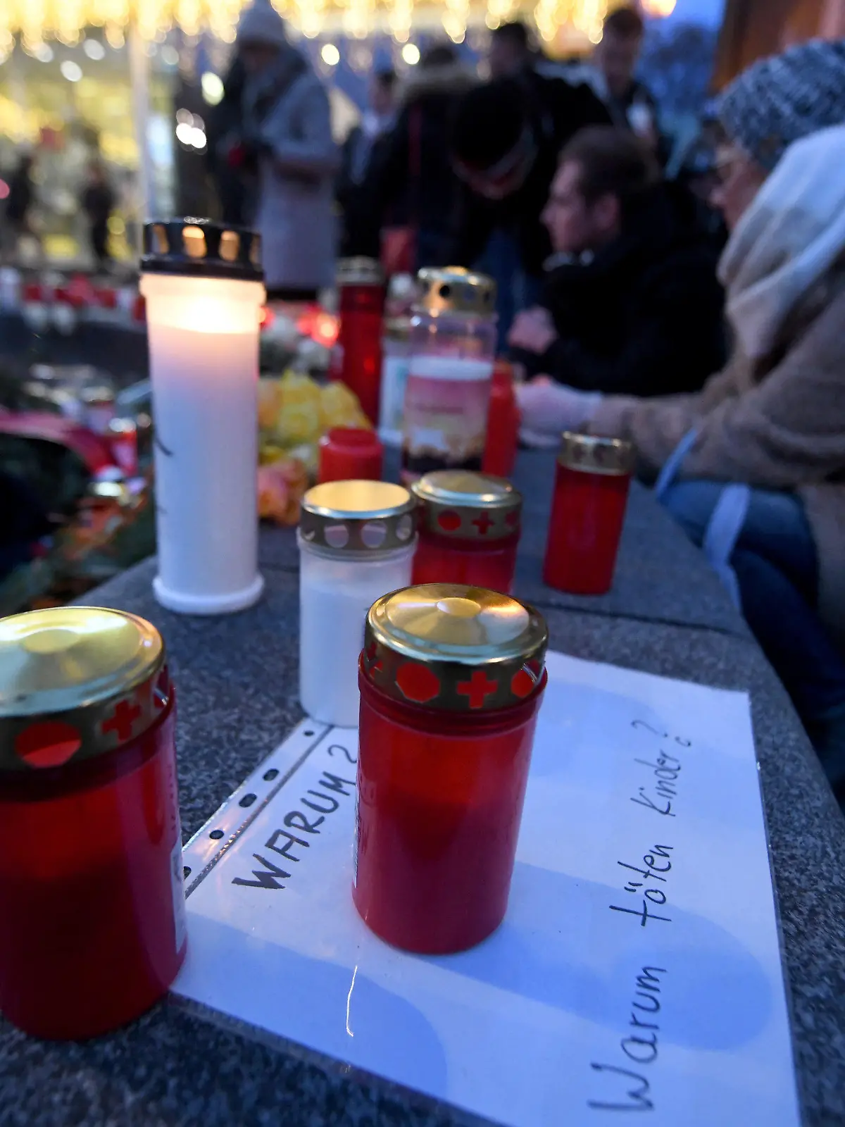 08.12.2019, Bayern, Augsburg: Ein Grablicht steht auf einem Zettel "Warum? Warum töten Kinder?" am Königsplatz. Ein Feuerwehrmann war am Freitagabend (06.12.2019) hier in seiner Freizeit nach einem Schlag so schwer verletzt worden, dass er noch vor Ort starb Foto: Stefan Puchner/dpa +++ dpa-Bildfunk +++