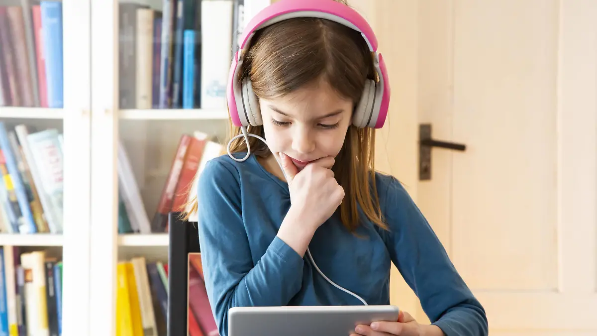  Little girl doing homework with headphones and digital tablet model released Symbolfoto property released PUBLICATIONxINxGERxSUIxAUTxHUNxONLY LVF07945