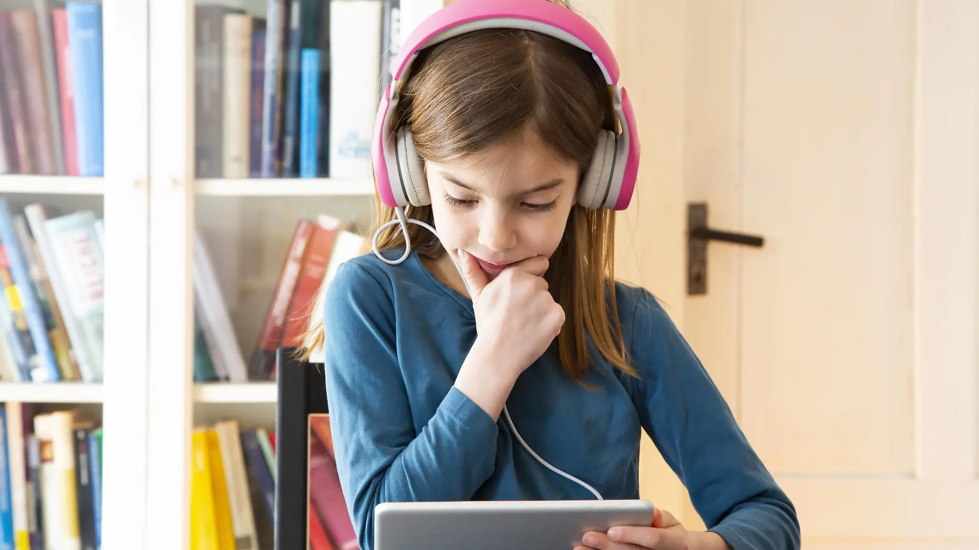 Little girl doing homework with headphones and digital tablet model released Symbolfoto property released PUBLICATIONxINxGERxSUIxAUTxHUNxONLY LVF07945