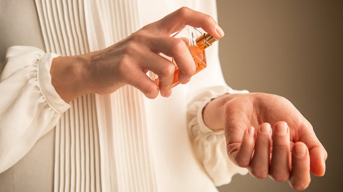 Frau sprüht qualitativ hochwertiges Parfum auf.