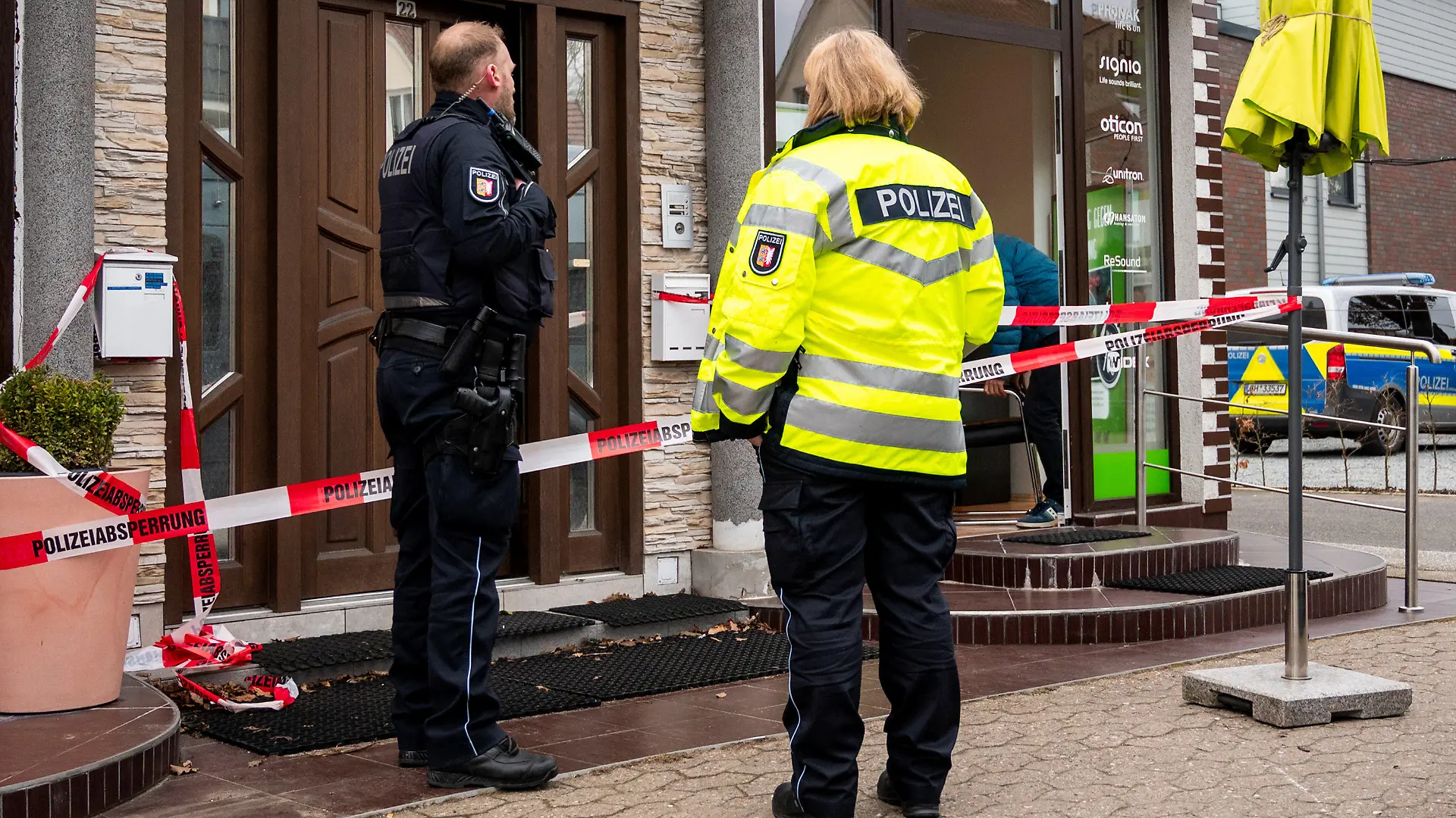 09.03.2023, Schleswig-Holstein, Aumühle: Polizisten stehen vor einem Wohn- und Geschäftshaus. Eine 41-jährige Frau ist dort tot gefunden worden, die Ermittler gehen von einem Gewaltverbrechen aus. (zu dpa: «41-Jährige in Aumühle tot gefunden - Ehemann unter Tatverdacht») Foto: Daniel Bockwoldt/dpa +++ dpa-Bildfunk +++