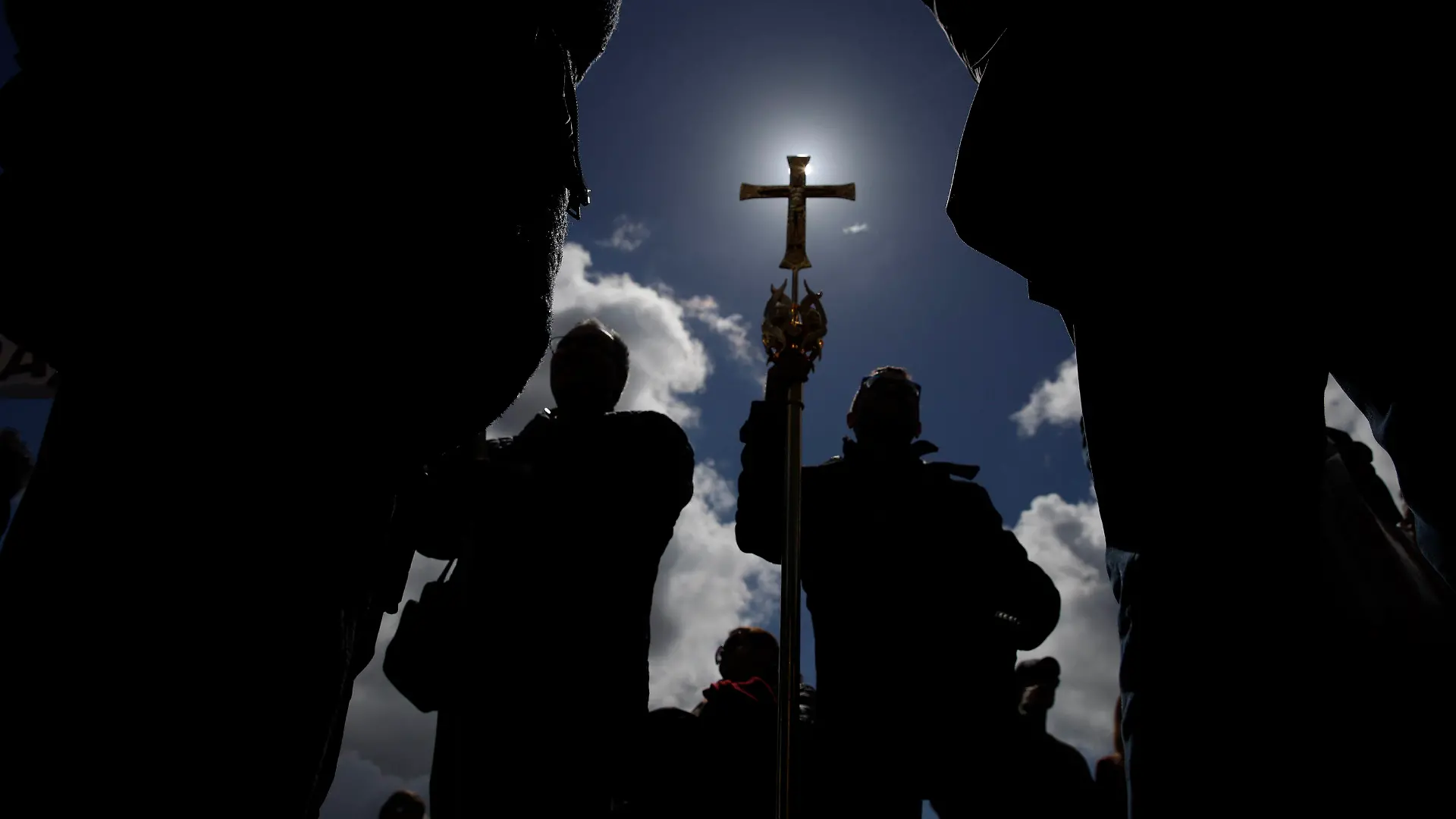 ARCHIV - 07.04.2019, Vatikan, Vatikanstadt: Ein Gläubiger hält auf dem Petersplatz während des Angelus-Gebets ein Kreuz. Wer Geld hat, muss es gut anlegen. Das gilt auch für den Vatikan. Doch ein Immobiliendeal in London ist zum Fall für die Justiz geworden. Erinnerungen an frühere Finanzskandale werden wach. (zu dpa ««Hässliche Sache» - Finanzskandal hält Vatikan in Atem») Foto: Alessandra Tarantino/AP/dpa +++ dpa-Bildfunk +++