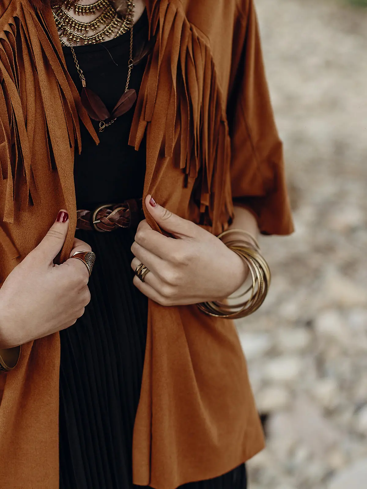 stylish hipster boho traveler woman look. gypsy girl in fringe jacket with feather bronze accessory. wanderlust summer travel. atmospheric moment. space for text.