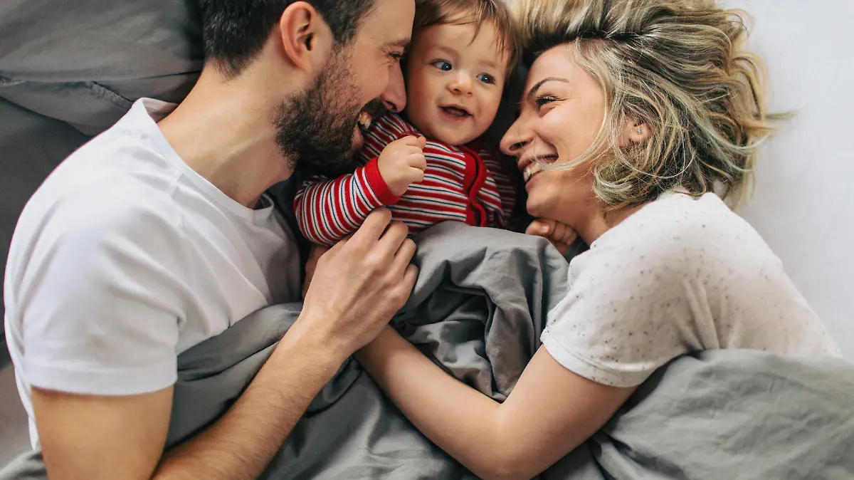 Familie kuschelt im Bett