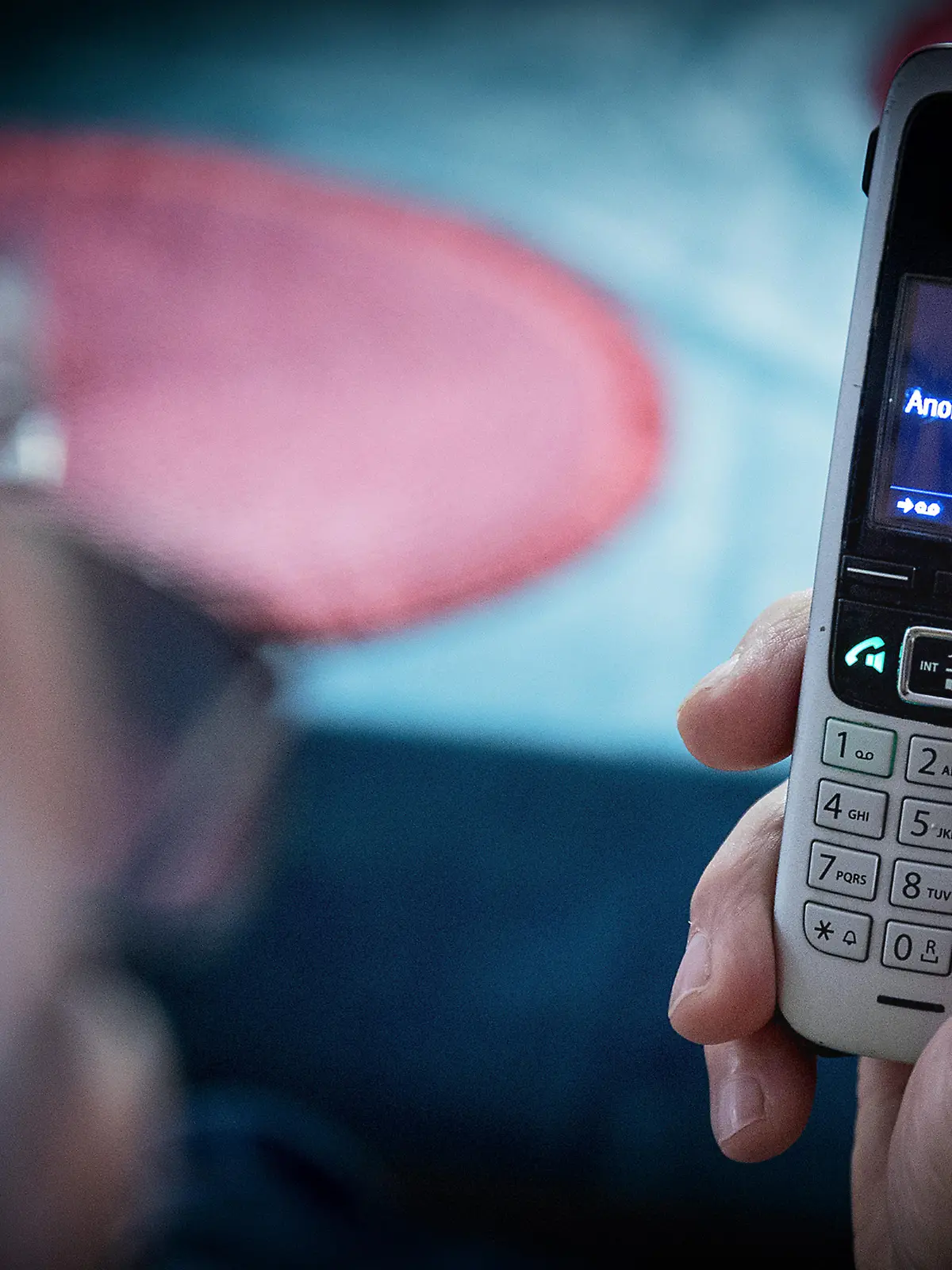 Bamberg, Deutschland 26. Dezember 2022: Themenbilder - Symbolbilder - Telefonbetrug - 2022 Ein älterer Menschen sitzt in seiner Wohnung und hält ein Telefon, Mobilteil in der Hand. Auf dem Display steht keine Rufnummer sondern Anonym. Viele Senioren und Seniorinnen werden Opfer von Telefonbetrug, darunter fällt auch der Enkeltrick oder auch der Schockanruf Bei diesen Anrufen werden teilweise auch Telefonnummern manipuliert, welche dann auf dem Mobilteil angezeigt werden.