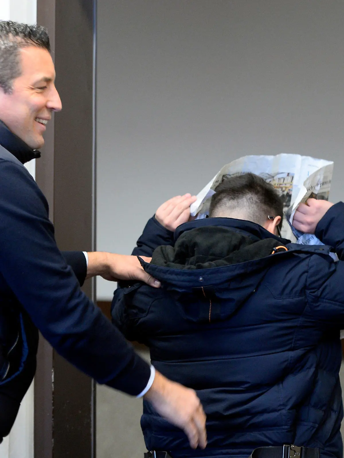 22.11.2019, Nordrhein-Westfalen, Köln: Einer der Angeklagten (r) verlässt kurz vor der Urteilsverkündigung im Prozess im Landgericht gegen Mitglieder einer Leverkusener Grossfamilie den Saal, um sich zu besprechen. Den Angeklagten wird vorgeworfen, ein älteres Ehepaar um ein Millionen Euro betrogen zu haben. Foto: Roberto Pfeil/dpa +++ dpa-Bildfunk +++