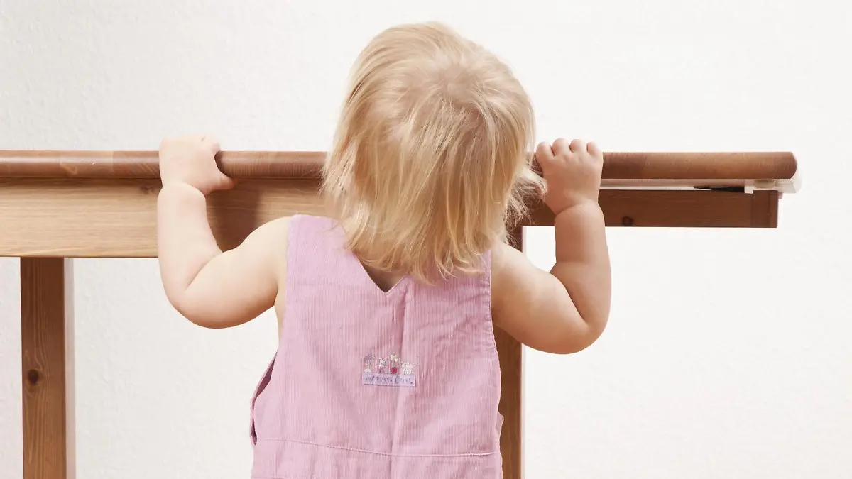 Baby steht an Tisch