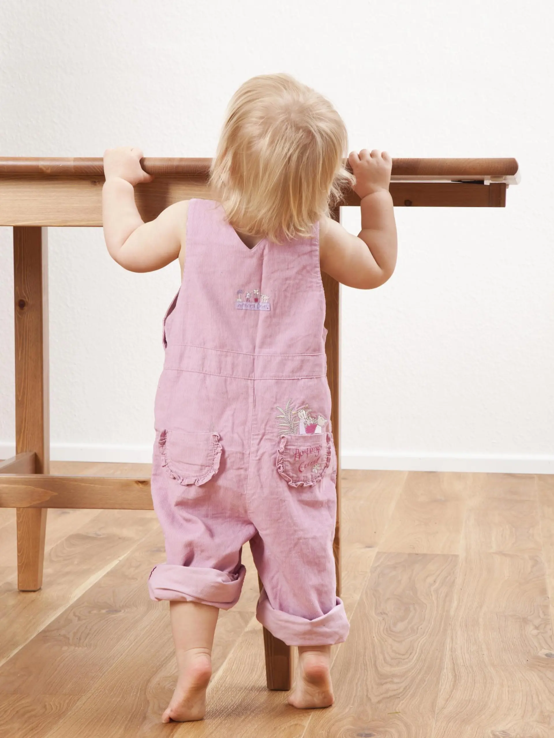 Baby steht an Tisch