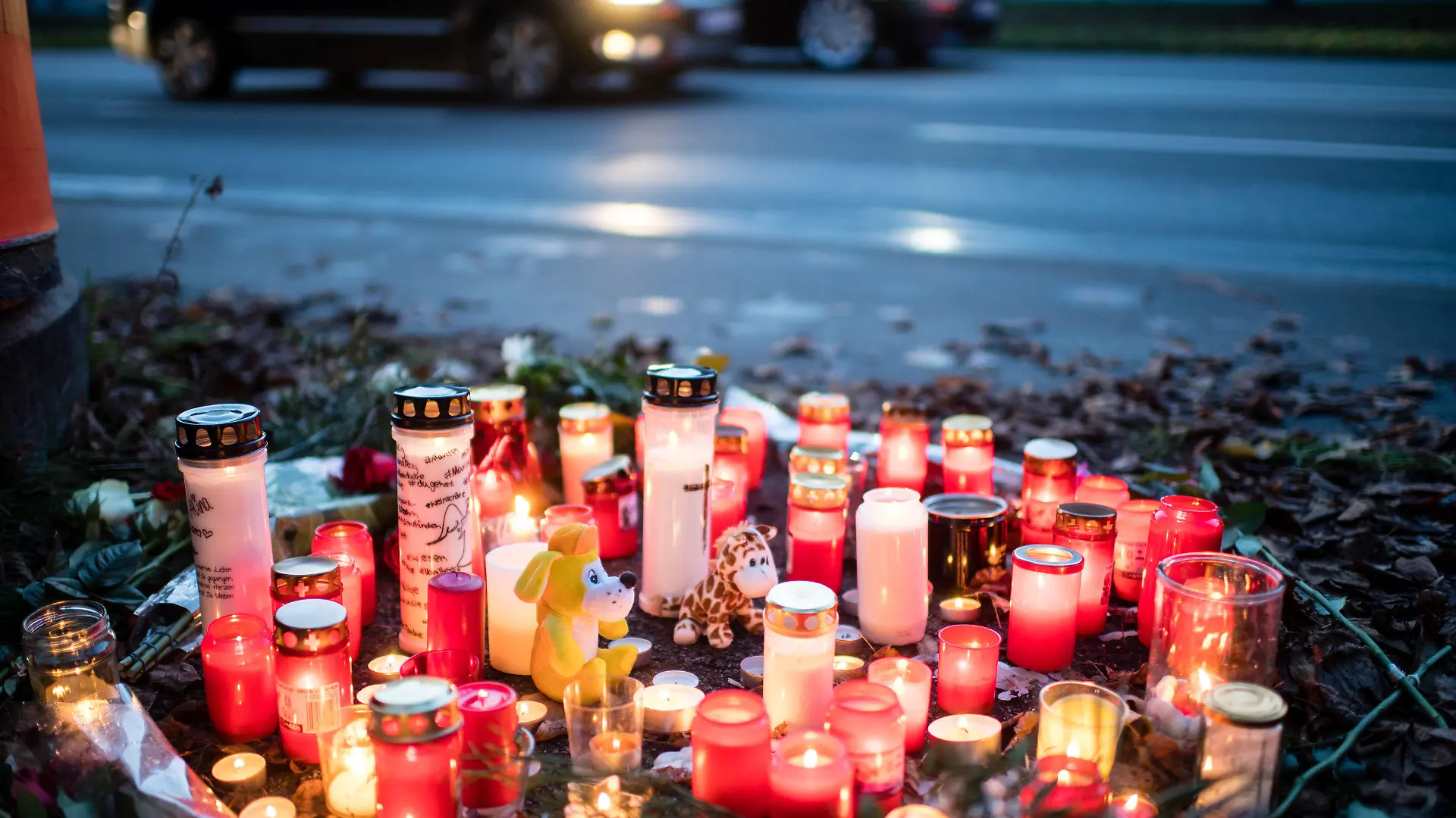 17.11.2019, Bayern, München: Kerzen und Blumen liegen an der Unfallstelle, an der am 15.11. ein 14-Jähriger zu Tode gekommen ist. Auf der Flucht vor der Polizei hat ein Autofahrer mehrere rote Ampeln missachtet und ist dabei in eine Gruppe Jugendlicher gerast. Inzwischen wurde gegen den Fahrer Haftbefehl wegen Mordes erlassen. Foto: Matthias Balk/dpa +++ dpa-Bildfunk +++
