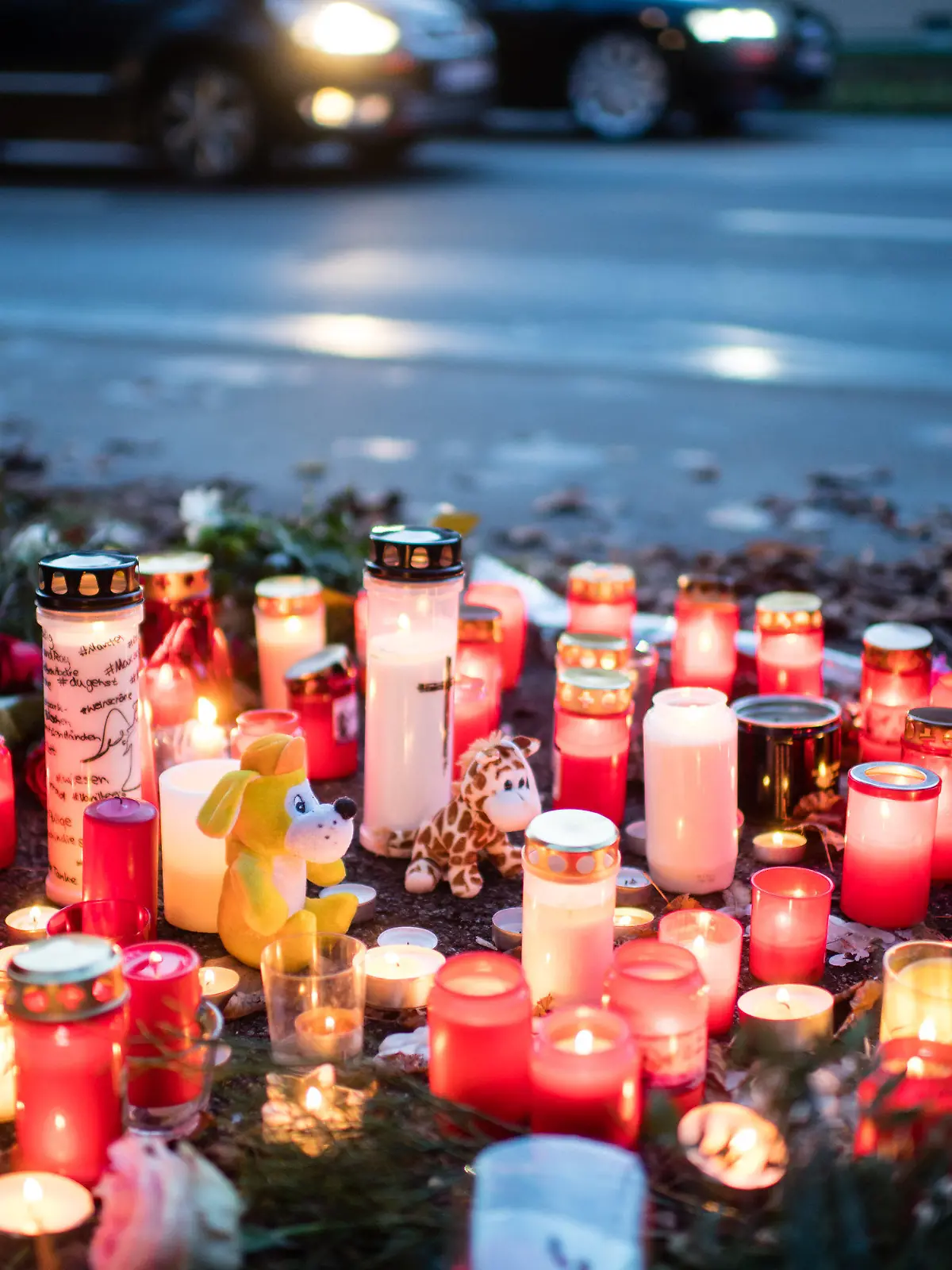 17.11.2019, Bayern, München: Kerzen und Blumen liegen an der Unfallstelle, an der am 15.11. ein 14-Jähriger zu Tode gekommen ist. Auf der Flucht vor der Polizei hat ein Autofahrer mehrere rote Ampeln missachtet und ist dabei in eine Gruppe Jugendlicher gerast. Inzwischen wurde gegen den Fahrer Haftbefehl wegen Mordes erlassen. Foto: Matthias Balk/dpa +++ dpa-Bildfunk +++
