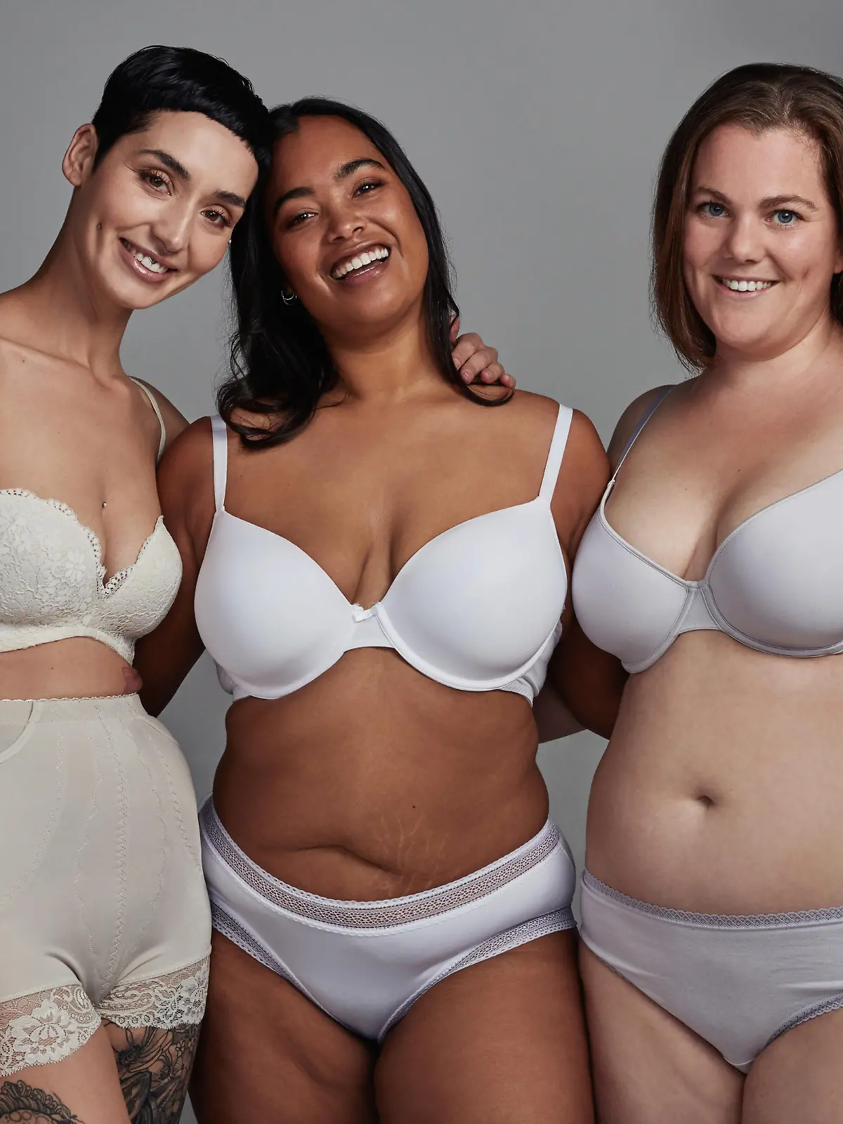 Shot of three young women posing in their underwear against a grey background