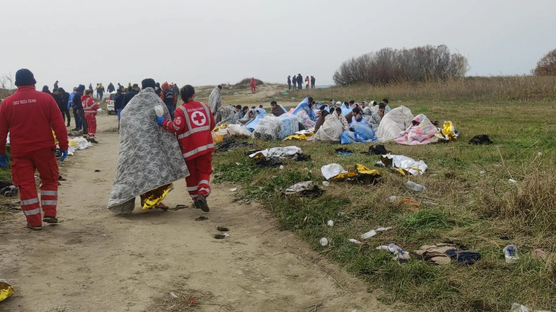 February 26, 2023, CUTRO: Red Cross personnel stand next to survivors after they washed ashore following a shipwreck, at a beach near Cutro, Crotone province, southern Italy, 26 February 2023. Italian authorities recovered at least 40 bodies on the beach and in the sea near Crotone, in the southern Italian region of Calabria, after a boat carrying migrants sank in rough seas near the coast. About forty people survived the accident. Authorities fear the death toll will climb as rescuers look for survivors..ANSA/ GIUSEPPE PIPITA CUTRO - ZUMAa110 20230226_zaf_a110_018 Copyright: xGiuseppexPipitax