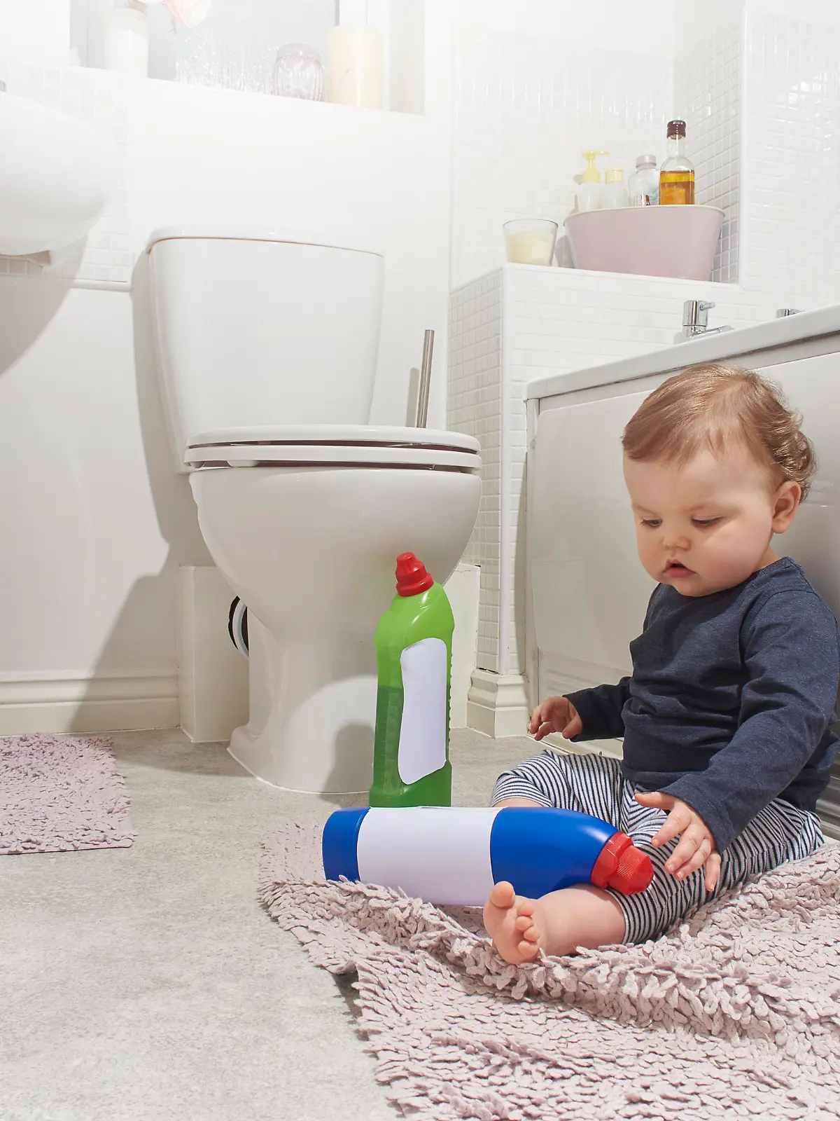 Baby boy finds bleach and other cleaning products not put out of harms reach in the bathroom while his parents are distracted.