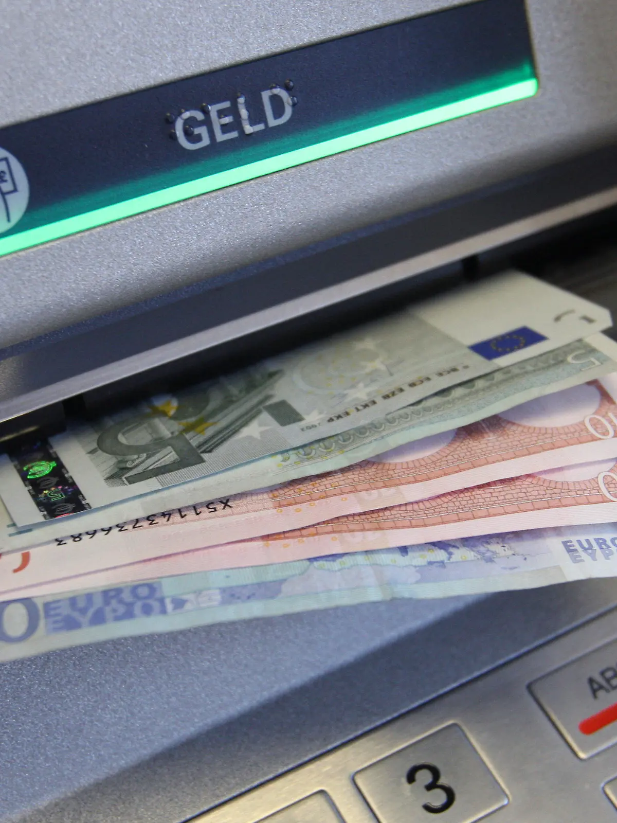 ARCHIV - ILLUSTRATION - Verschiedene Banknoten klemmen am 07.01.2010 im Ausgabefach eines Geldautomaten einer Sparkasse in Kaufbeuren (Bayern). Das Abheben und Zahlen mit Bargeld hat bei den Brandenburgern nach wie vor einen hohen Stellenwert. (zu «Kein Ende des Bargelds in Brandenburg in Sicht» vom 28.07.2017) Foto: Karl-Josef Hildenbrand/dpa +++(c) dpa - Bildfunk+++