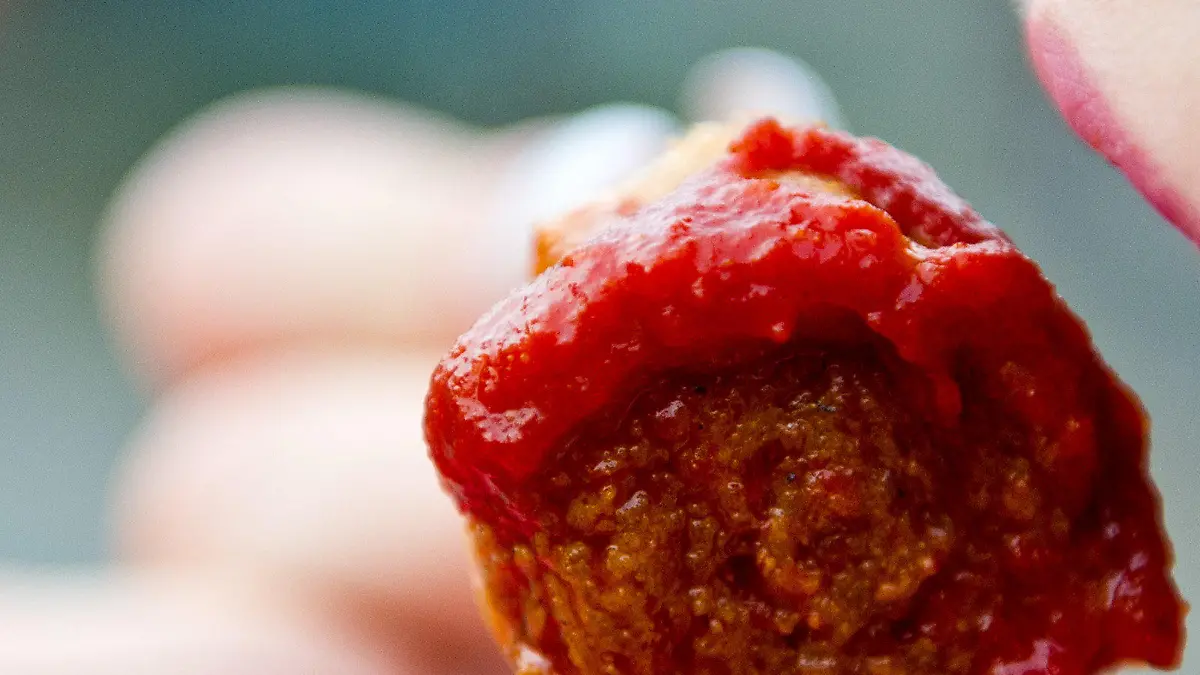 ARCHIV - Eine Frau isst am 14.02.2014 in Berlin ein an einem Imbiss ein Stück Currywurst. Knapp jeder zweite Deutsche isst nach einer Umfrage aus Gründen des Umwelt- oder Klimaschutzes weniger Fleisch. (zu dpa "Umfrage: Viele essen weniger Fleisch - nach eigenen Angaben" vom 13.01.2017) Foto: Daniel Bockwoldt/dpa +++(c) dpa - Bildfunk+++