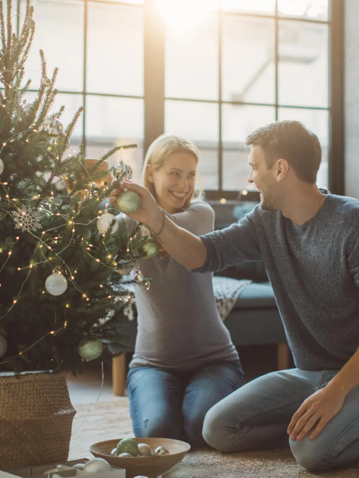 Schwangere Frau schmückt Weihnachtsbaum