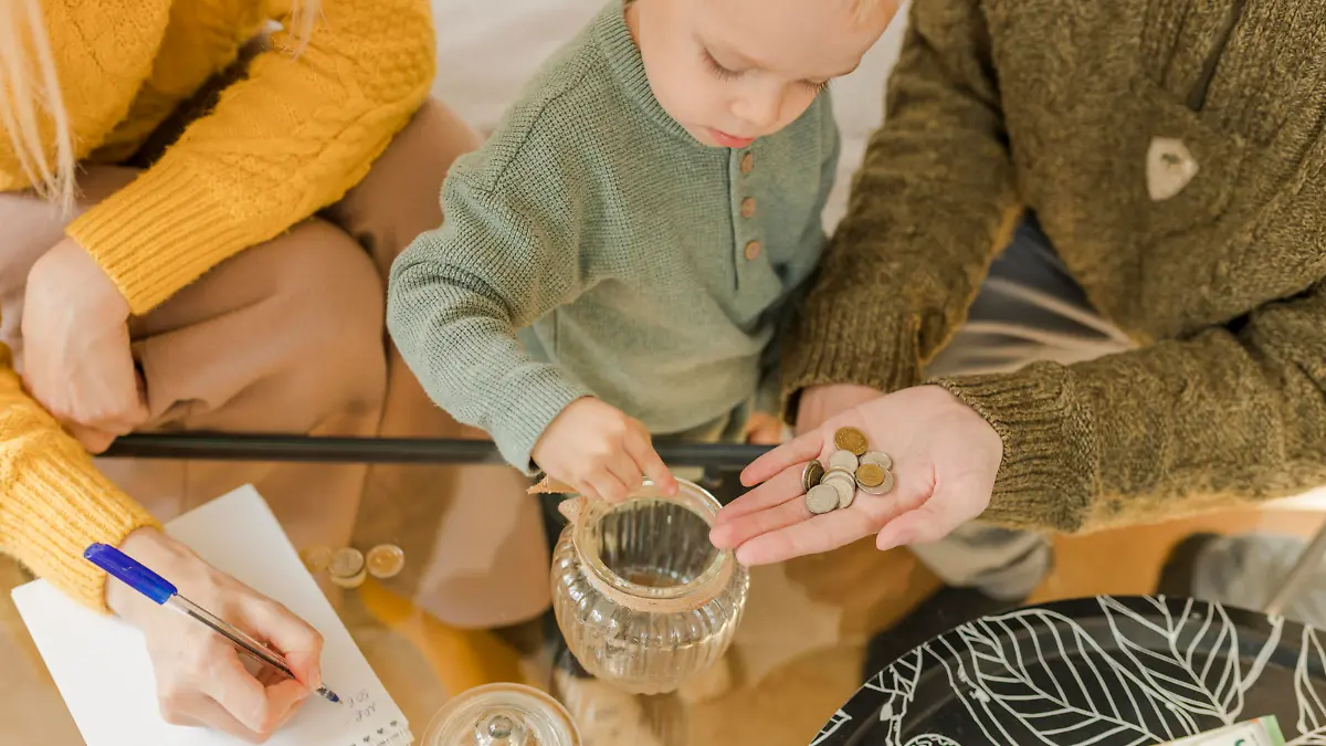 Parents with boy counting coins at home || Modellfreigabe vorhanden