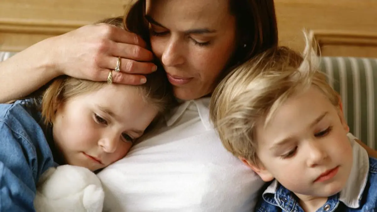 Eine Mutter hält ihre zwei Kinder im Arm.