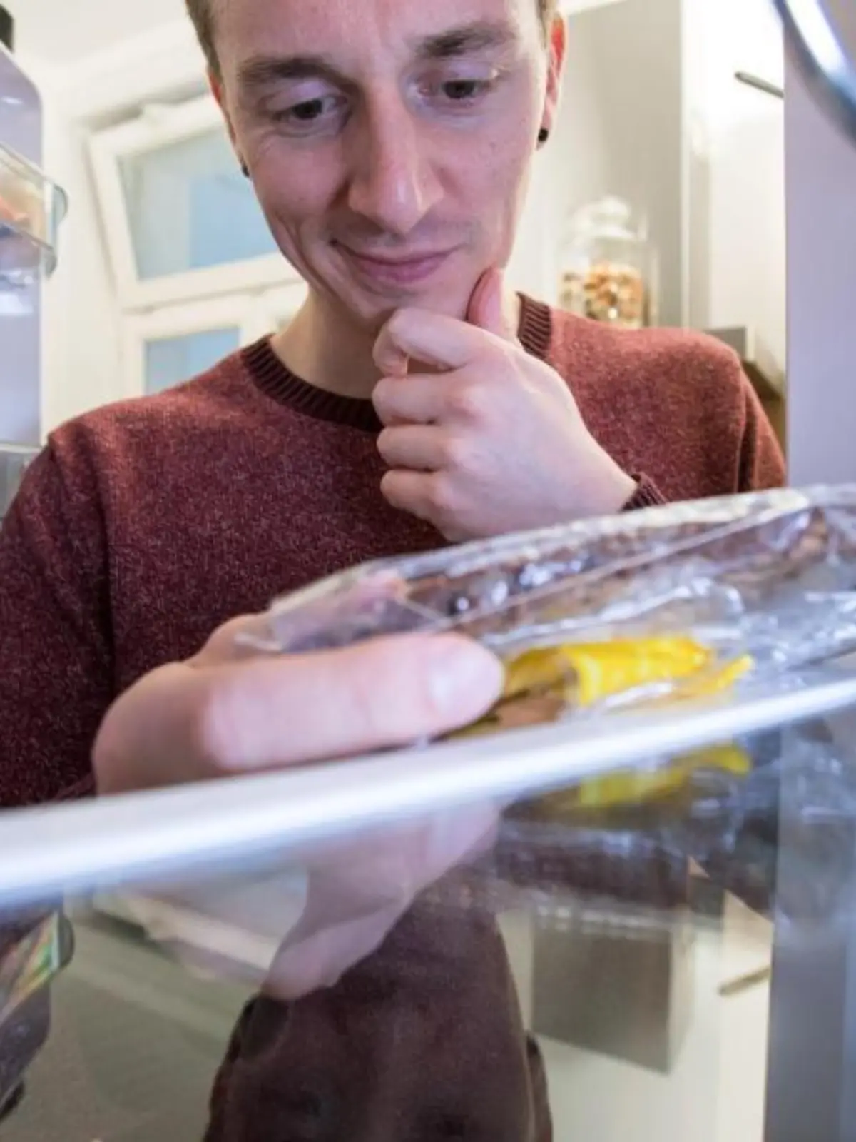 Mann guckt in Kühlschrank