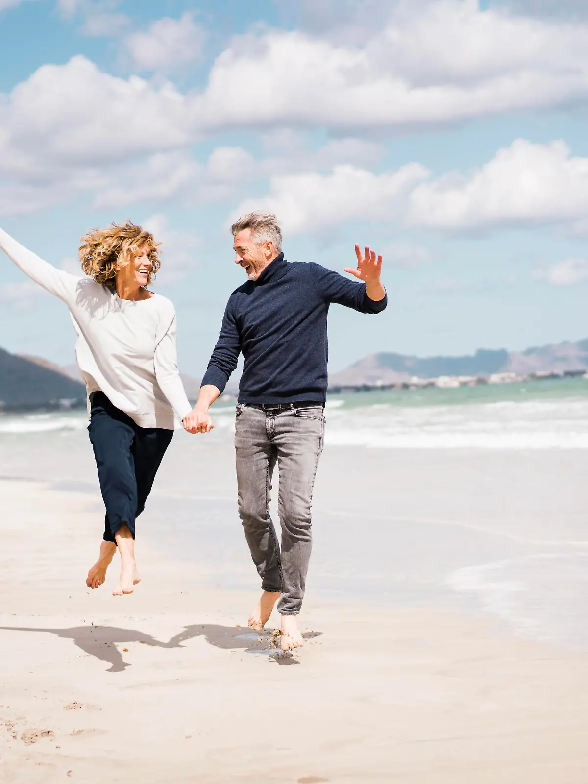 Cheerful mature couple having fun on shore at beach model released, Symbolfoto, JOSEF11419