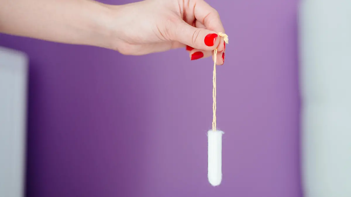 Frau hält Tampon in der Hand
