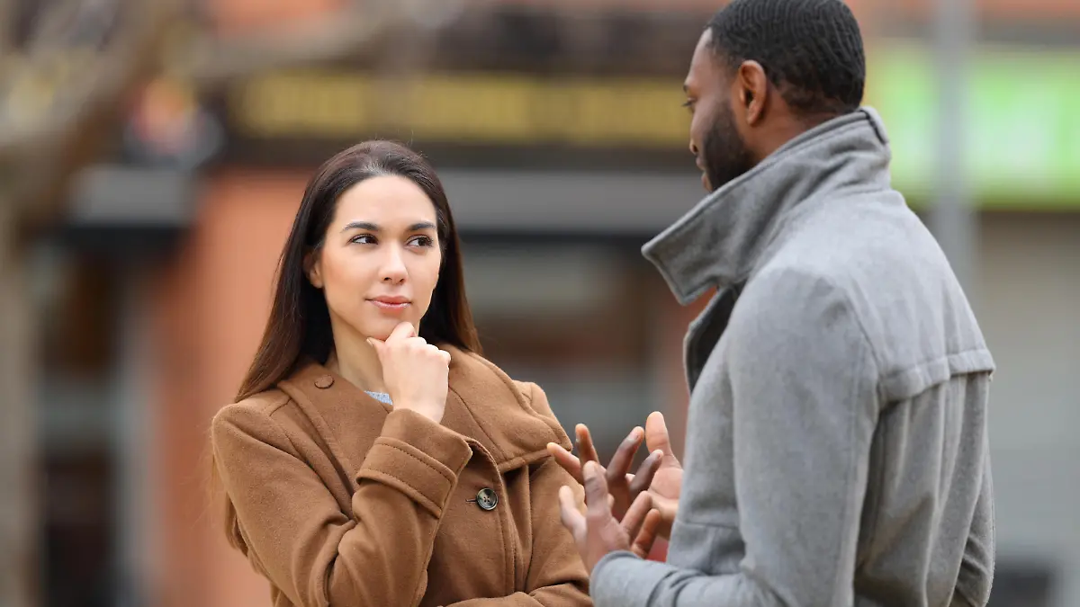 Suspicious woman listening a man talking in the street, Suspicious woman listening a man talking in the street in winter, Suspicious woman listening a man talking in the street in winter model released, Symbolfoto , 02.01.2023, Copyright: xPheelingsMediax Panthermedia33405213.jpg