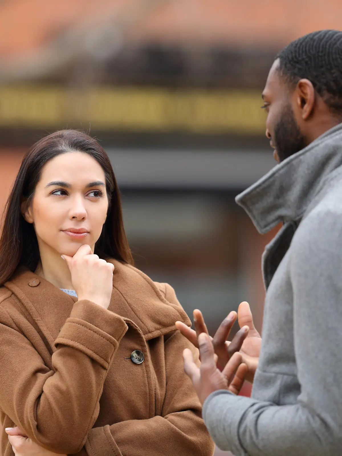 Suspicious woman listening a man talking in the street, Suspicious woman listening a man talking in the street in winter, Suspicious woman listening a man talking in the street in winter model released, Symbolfoto , 02.01.2023, Copyright: xPheelingsMediax Panthermedia33405213.jpg