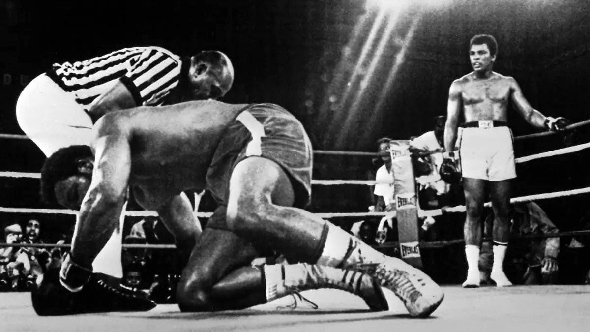 George Foreman (l) richtet sich wieder auf, nachdem er von Muhammad Ali (r) in der achten Runde des Schwergewichts-Weltmeisterschaftskampfes am 29.10.1974 in Kinshasa K.O. geschlagen wurde. Foreman verlor damit seinen Schwergewichtstitel an Ali.