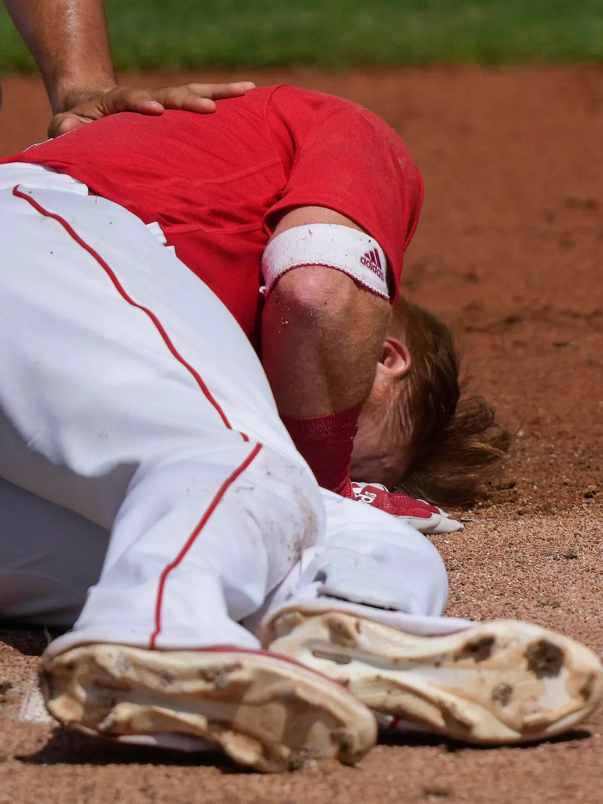 Boston Red Sox Justin Turner rolls on the ground after being hit in the face on a pitch by Detroit Tigers starting pitcher Matt Manning in the first inning of their spring training baseball game in Fort Myers, Fla., Monday, March 6, 2023. (AP Photo/Gerald Herbert)