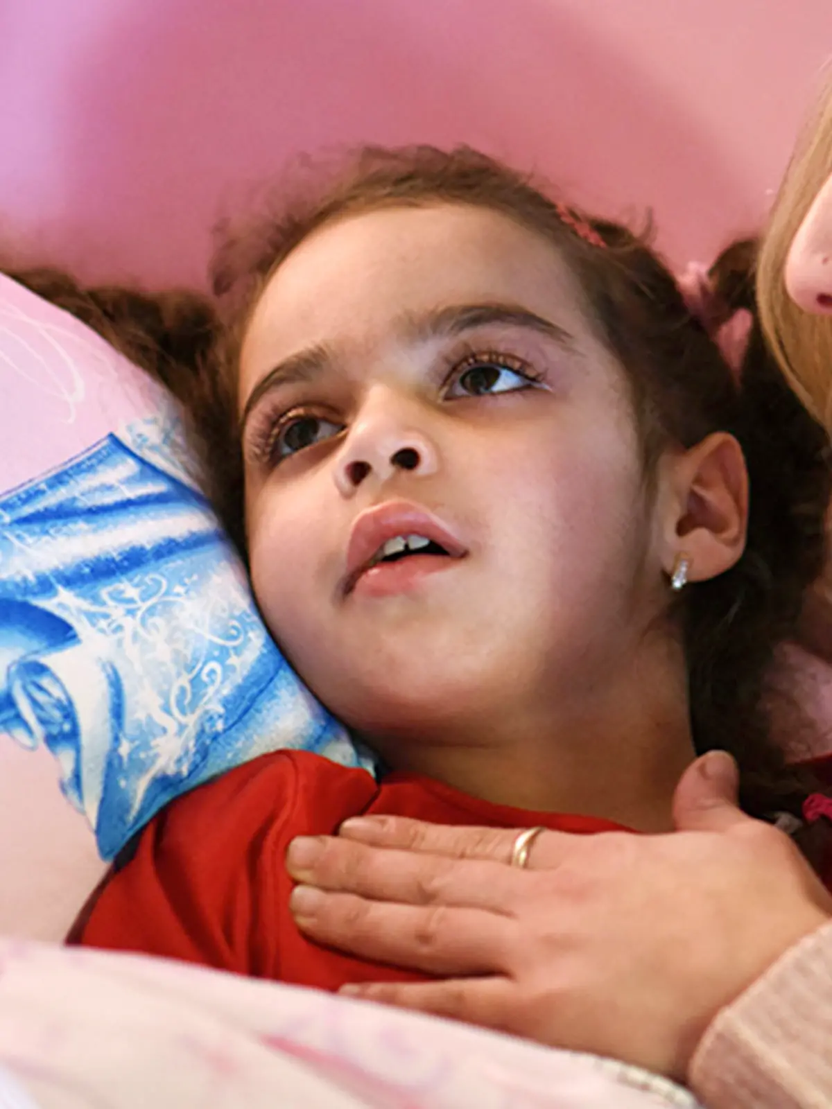 Mama Mirella Kunzmann (l) spricht am 30.10.2014 in Bad Hersfeld (Hessen) zu ihrer kranken Tochter Aliana. Sie leidet an der chronischen Maserngehirnentzündung SSPE, die Spätfolge einer Maserninfektion, die immer tödlich verläuft.