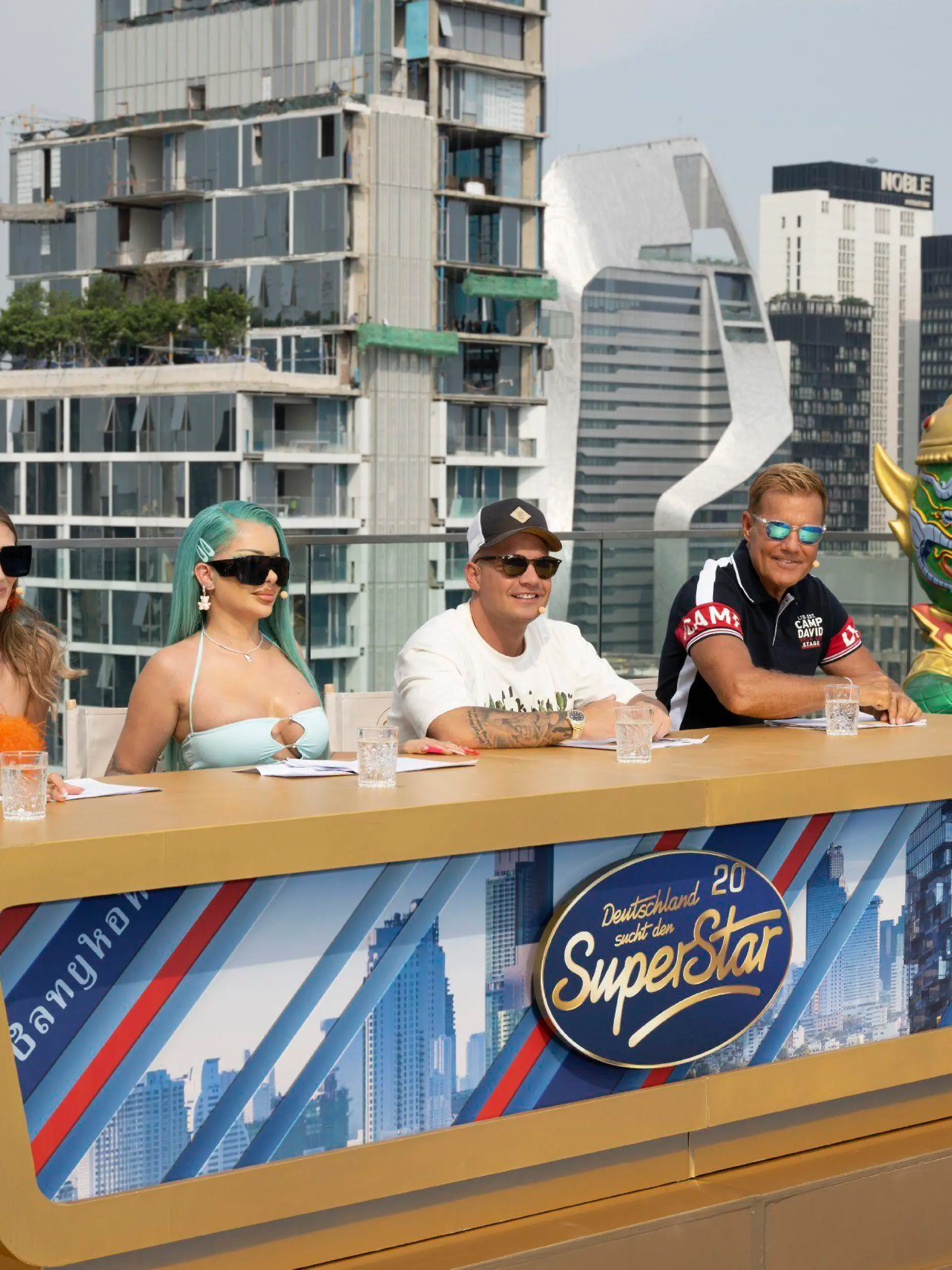Die Jury mit (v.l.) Leony, Katja Krasavice, Pietro Lombardi und Dieter Bohlen auf dem Rooftop des Sindhorn Midtown Hotels in Bangkok, dem ersten Set des Recalls in Thailand.

Die Verwendung des sendungsbezogenen Materials ist nur mit dem Hinweis und Verlinkung auf RTL+ gestattet.