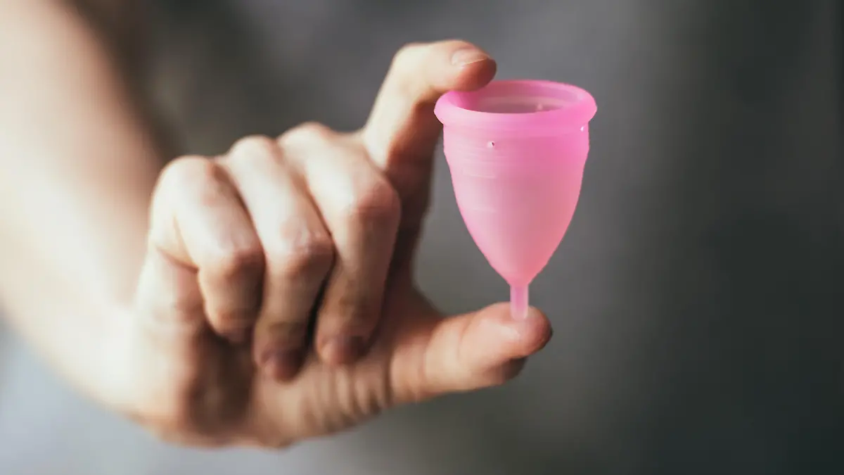 Young woman hand holding menstrual cup. Selective focus and shallow DOF