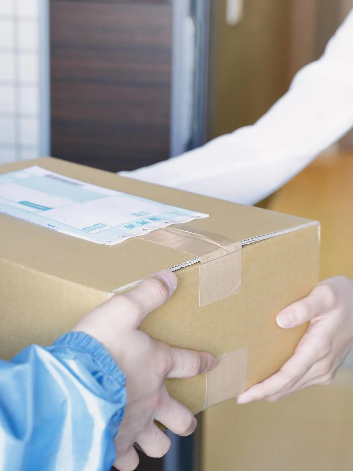  Young Japanese woman getting package from delivery man PUBLICATIONxINxGERxSUIxAUTxHUNxONLY jjig004118