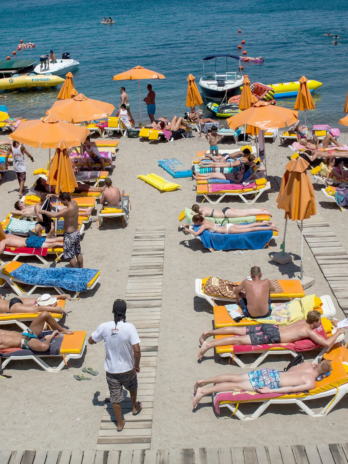 ARCHIV - 10.07.2015, Griechenland, Kos: Touristen genießen die Sonne an einem Strand nahe der Stadt Kos auf der gleichnamigen griechischen Insel. Die Chancen auf Urlaub am Mittelmeer steigen: Bundesaußenminister Maas verständigte sich am 18.05.2020 mit seinen Kollegen aus zehn der beliebtesten Urlaubsländer der Deutschen darauf, auf eine Öffnung der Grenzen für Touristen bis zum Sommerbeginn hinzuarbeiten. (Zu dpa "Urlaub am Mittelmeer rückt näher - Maas will Reisewarnung aufheben") Foto: Santi Palacios/dpa +++ dpa-Bildfunk +++