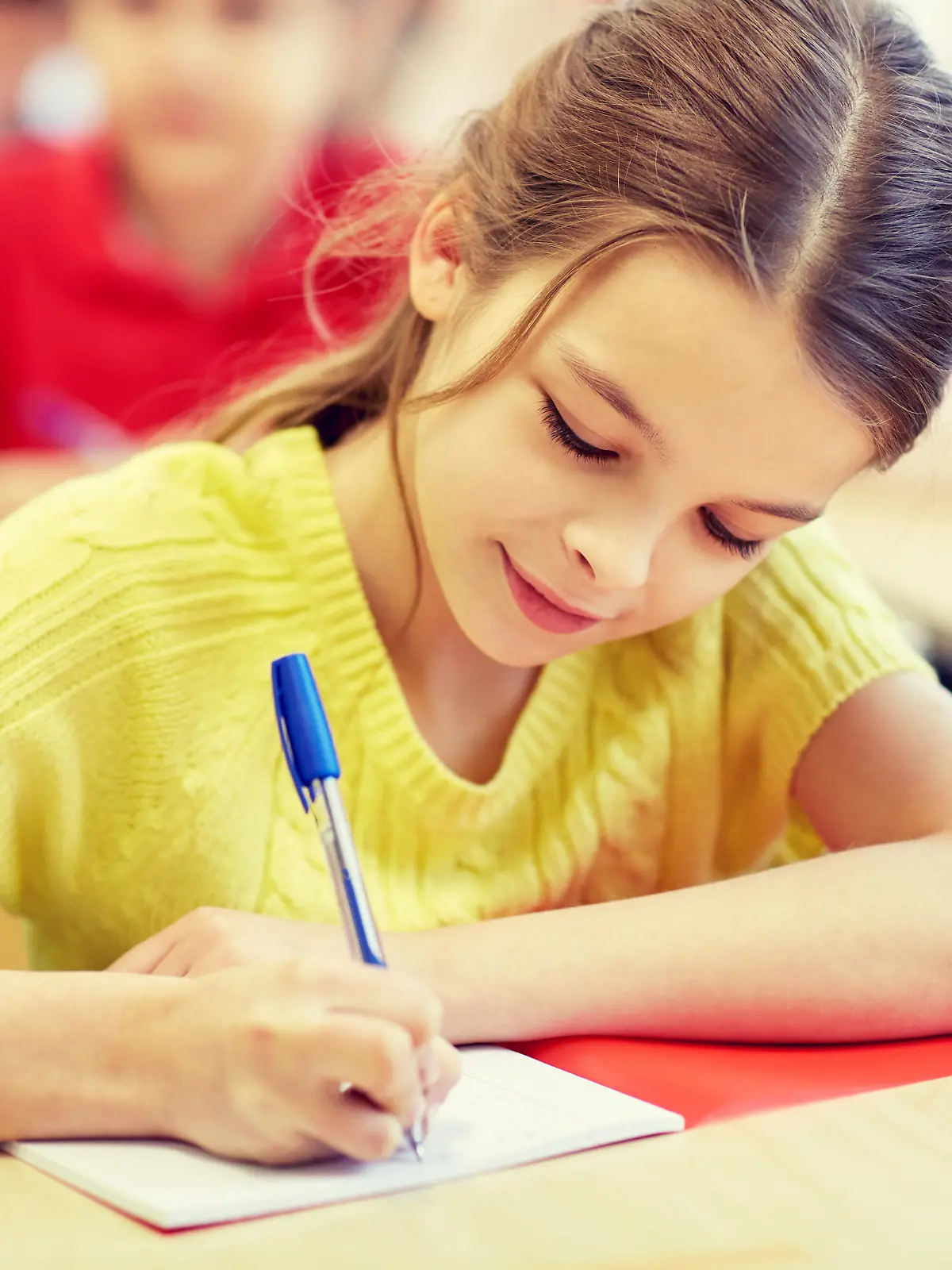 education, elementary school, learning and people concept - group of school kids with pens and notebooks writing test in classroom