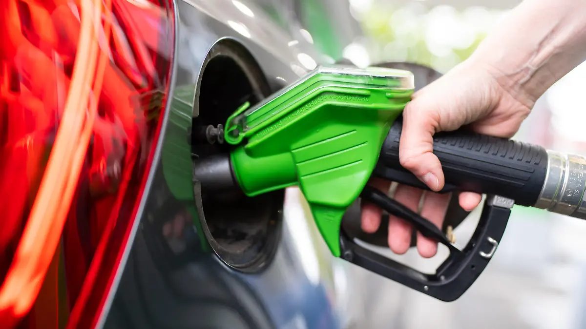 ARCHIV - 06.09.2020, Bayern, München: Eine Frau hält an einer Tankstelle an einer Zapfsäule eine Zapfpistole in der Hand und betankt ein Auto (zu dpa "EU-Kommissar: Ermäßigte Mehrwertsteuer auf Energie nicht beste Lösung") Foto: Sven Hoppe/dpa +++ dpa-Bildfunk +++