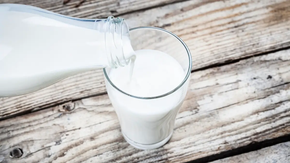Milch wird in Glas eingeschenkt.