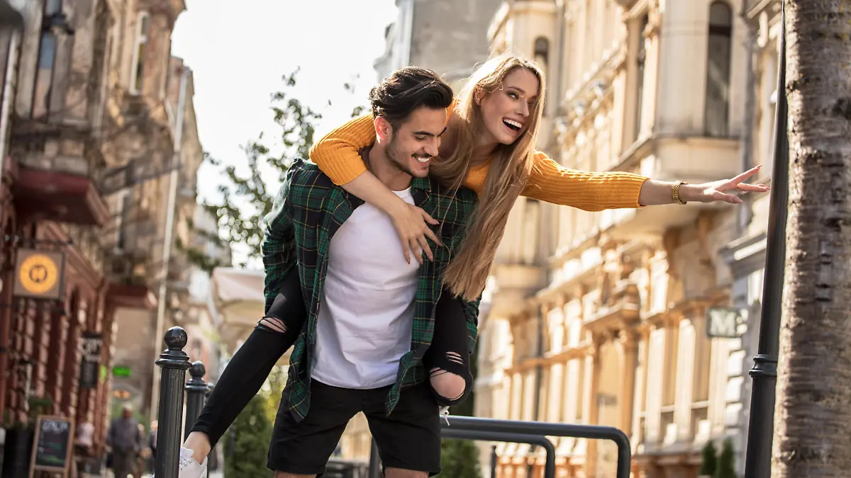 Smiling beautiful young couple in love, on the city street, dating and having fun together.