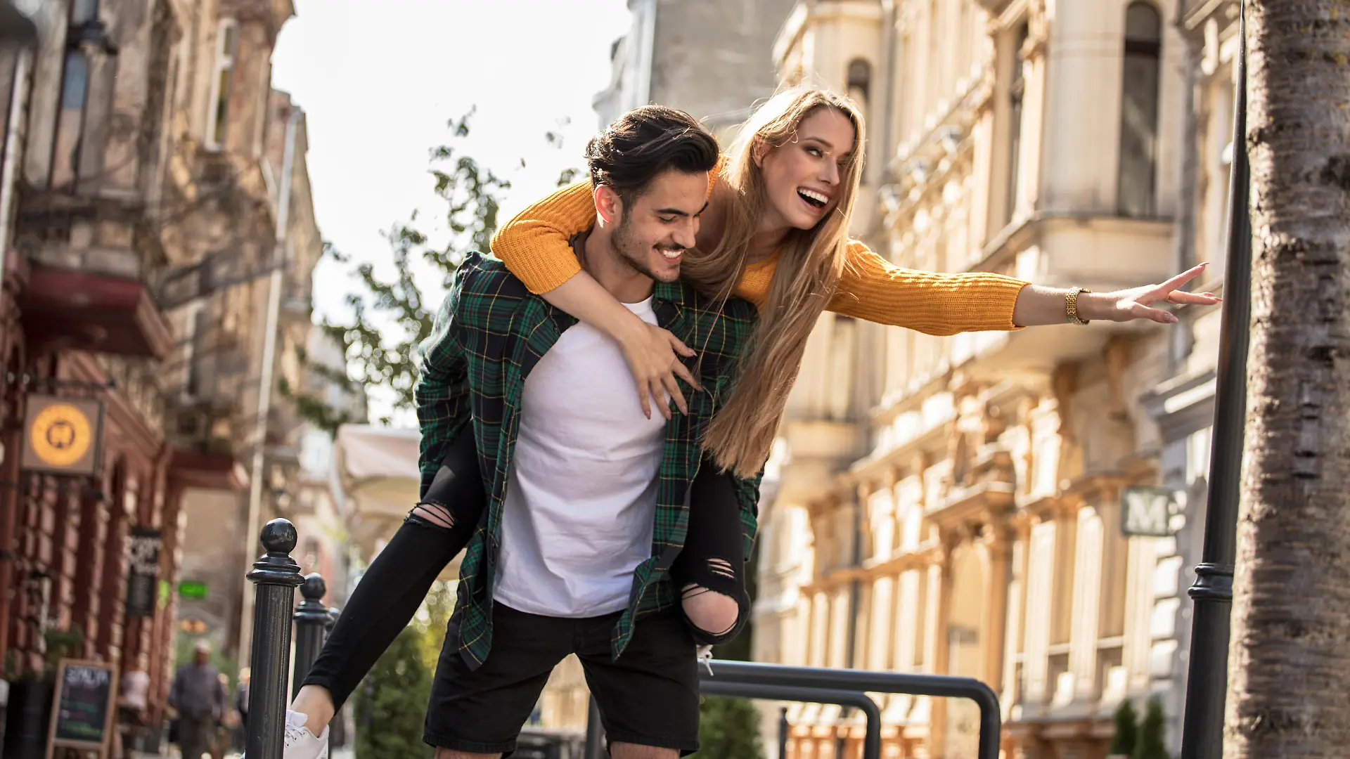 Smiling beautiful young couple in love, on the city street, dating and having fun together.