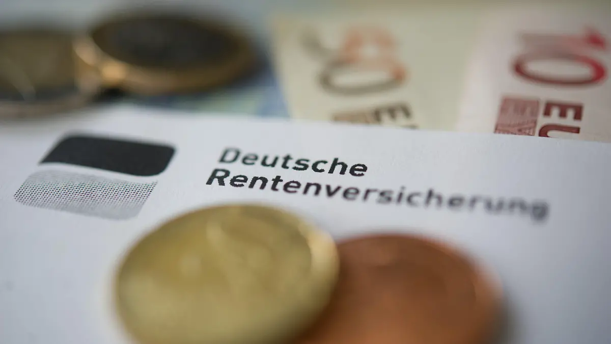 ARCHIV - 21.06.2012, Baden-Württemberg, Stuttgart: ILLUSTRATION - Münzen und Geldscheine liegen neben einem Schreiben mit der Aufschrift «Deutsche Rentenversicherung». (zu dpa «Erwerbstätige ziehen höhere Rentenbeiträge einer späteren Rente vor») Foto: Marijan Murat/dpa +++ dpa-Bildfunk +++