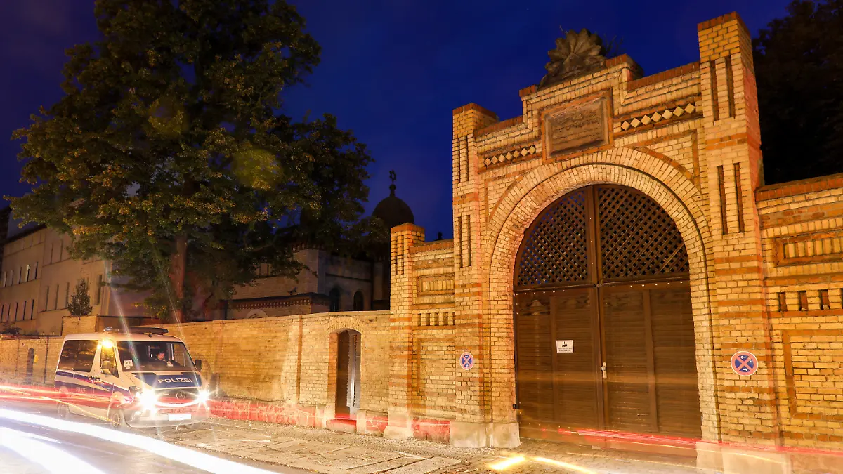 10.10.2019, Sachsen-Anhalt, Halle: Polizisten in einem Polizeifahrzeug stehen vor der Synagoge in Halle. Am Vortag hatte hier ein schwerbewaffneter Täter versucht, in die Synagoge einzudringen und dort unter Dutzenden Gläubigen ein Blutbad anzurichten. (Aufnahme mit Langzeitbelichtung) Foto: Jan Woitas/dpa-Zentralbild/dpa +++ dpa-Bildfunk +++