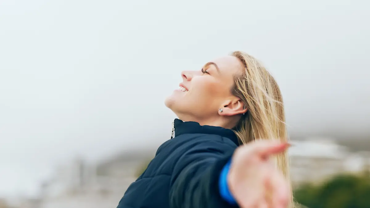 Happy woman, outdoor freedom arms out in wind, breathe fresh air or purpose, happiness and motivation, peace and dream, calm or hope. Smile lady, optimism and relax in nature, wellness or mindfulness