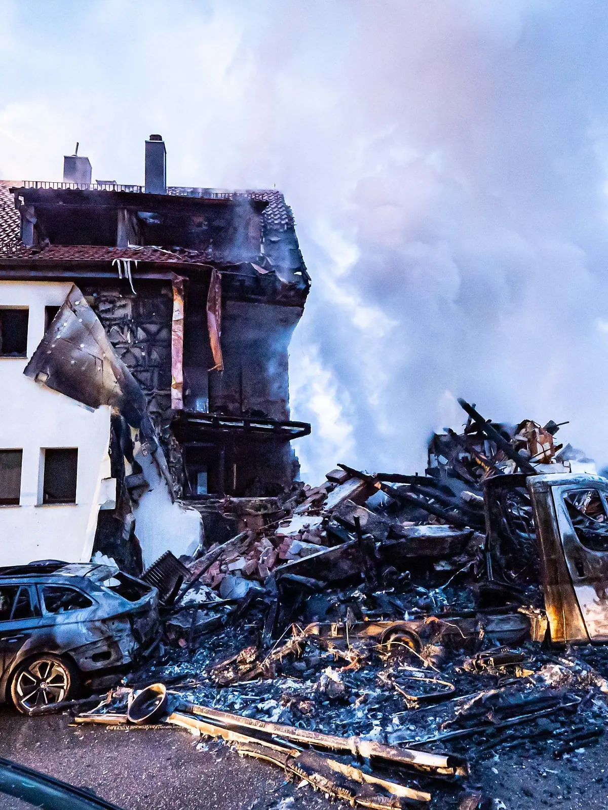 dpatopbilder - 06.03.2023, Baden-Württemberg, Stuttgart: Nach einer Explosion in einem Wohnhaus in Stuttgart sind Teile des Gebäudes eingestürzt. Vier Menschen, darunter zwei Kinder, wurden am Montagmorgen verletzt, wie ein Sprecher der Feuerwehr mitteilte. Eine 85-Jährige werde vermisst. Vermutlich ist eine Gasexplosion der Grund für das Feuer. Foto: Alexander Hald/vmd-images/dpa +++ dpa-Bildfunk +++