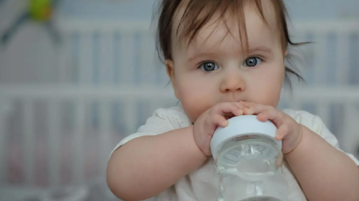 Baby trinkt Wasser aus Flasche