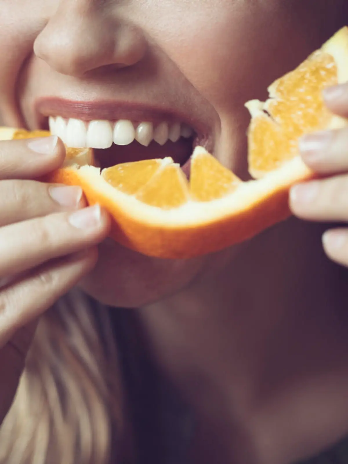 Frau isst Orange