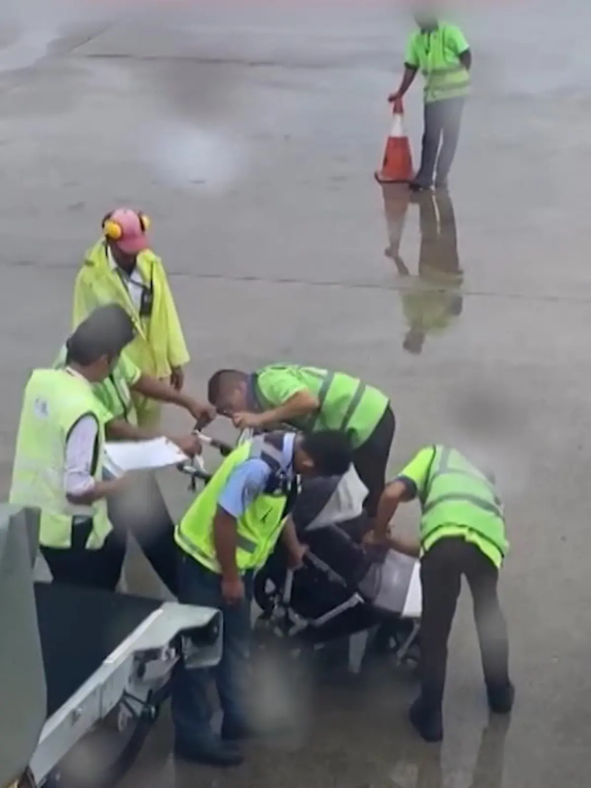 Die Flughafenmitarbeiter haben offensichtlich keine Ahnung, wie sie den Kinderwagen zusammengefaltet bekommen, stehen minutenlang rätselratend neben dem Gefährt. Ob der Flieger je abgehoben hat? Man weiß es nicht...